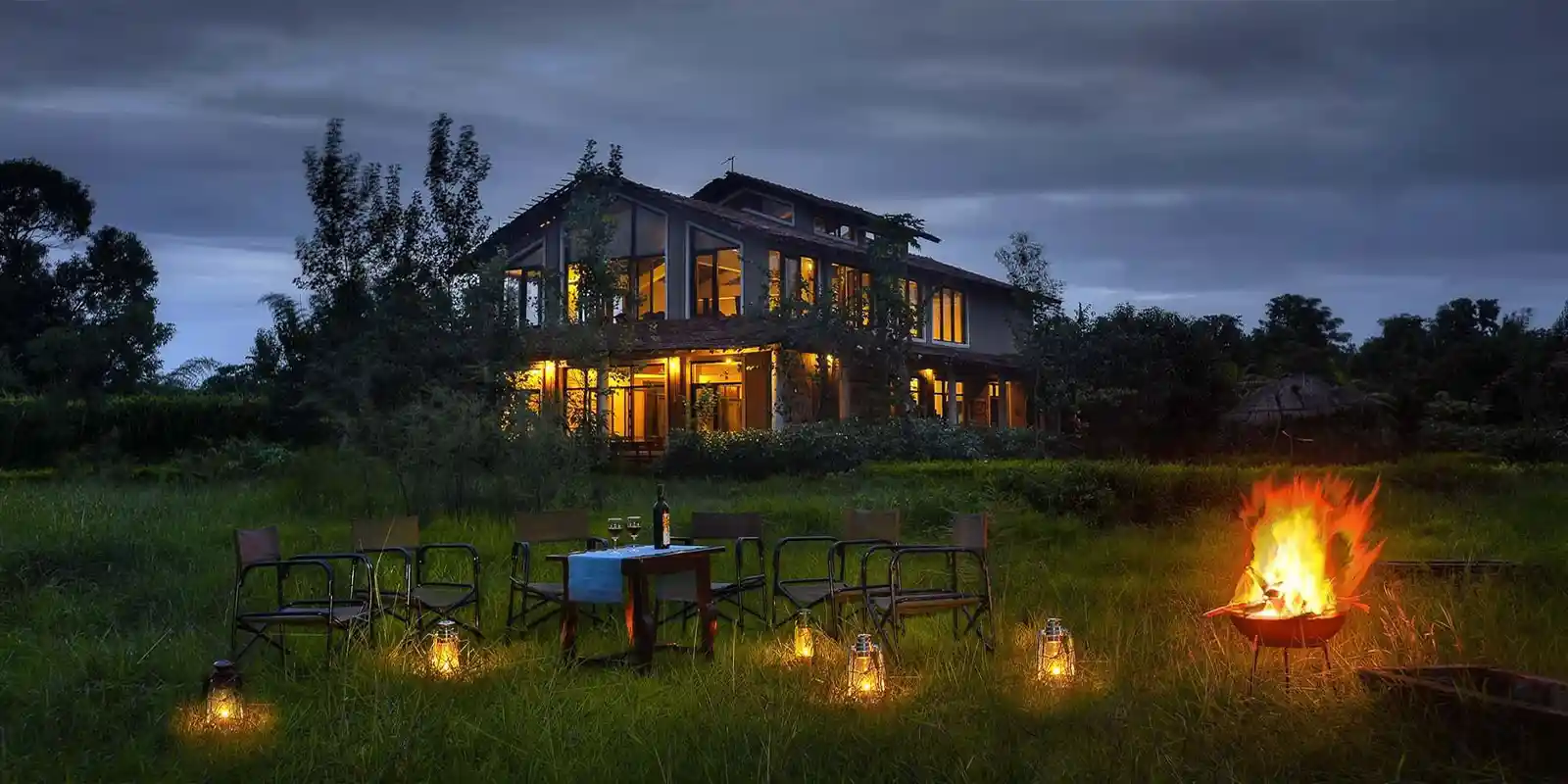 View of Chitvan Jungle Lodge in India during the evening, with a campfire