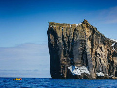 Zodiac near cliff in Antarctica.