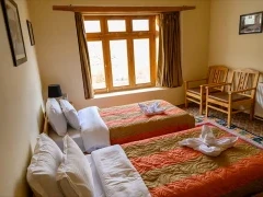 Twin bedroom at Snow Leopard Lodge in Ulley Valley, India.