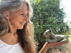 Client with lion sculpture on our Wildlife Art Safari in South Luangwa, Zambia