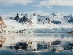 View of a glacier and looming mountains in Svalbard.