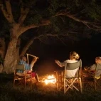 Guests seated around a fire pit at Ol Gaboli Lodge, Kenya.