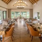 Dining area at Simbavati Camp George. The space is light and offers views all around the room.