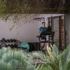 Gym facilities at Simbavati Camp George. Gym facilities include treadmill, rowing machine, weights, and yoga mats.