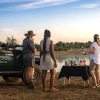 Guests enjoying sundowner drinks by a nearby watering hole, in Klaserie Private Nature Reserve.