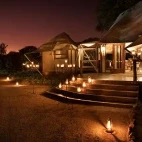 View of the Hamiltons Tented Camp entrance at night, with atmospheric candlelight.