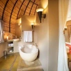En suite bathroom facilities at Hoyo Hoyo Safari Lodge, with stone bathtub and outdoor shower.