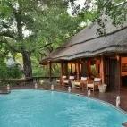 View of Imbali Safari Lodge's deck with pool, overlooking the surrounding landscape of Kruger National Park, South Africa.
