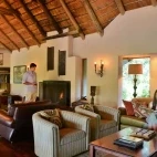 Guests enjoying Imbali Safari Lodge's lounge area, complete with open fire.