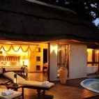 View of a suite in the evening, featuring lounge chairs and plunge pool. Imbali Safari Lodge.
