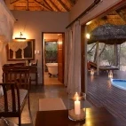 Internal view of a suite at Imbali Safari Lodge, with large French doors out to the decking and private plunge pool.