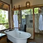 Bathroom suites at Rhino Post Safari Lodge, complete with bath and outdoor shower facilities.
