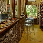 View of the bar seating area and wine racks at Rhino Post Safari Lodge.