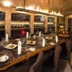 The wine cellar dining experience at Sabi Sabi Earth Lodge, featuring over 6,000 South African wine bottles lining the walls.