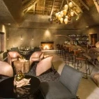 The bar area at Sabi Sabi Earth Lodge, with unique wood bar and open fire. Perfect for relaxing in the evening.