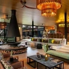 Luxurious bar and lounge area at Tanda Tula, complete with log fire and panoramic views of outside.