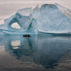 Boat approaching iceberg in Scoresby Sund, Greenland. 