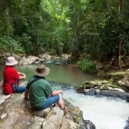 Guests by the creek at Rose Gums Wilderness Retreat, Australia.