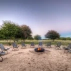 Outdoor seating by a campfire, in the grounds of Dinaka Camp, Botswana.