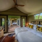View of a bedroom in the family suite, with large twin bed setup, at Karangoma, Botswana.