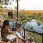 Guests viewing an elephant from their private deck at Shinde Footsteps Camp, Botswana.