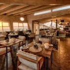 View of the dining area at Shipwreck Lodge, with the sun shining through the building.