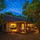Evening view of one of the meru-style tents, with thatch roof and private deck.