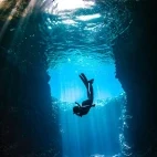 A woman snorkelling down into a cavern in Tonga, South Pacific.