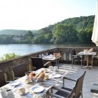 Outdoor dining area with river view at Les Magnolias, The Dordogne