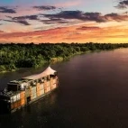 The Aria Amazon river boat cruising at sunset, Peru.