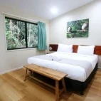 A bedroom with a king-sized bed, at Chambers Wildlife Lodge, Australia
