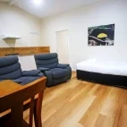 A lodge lounge and kitchen area, featuring a single bed, at Chambers Wildlife Lodge, Australia