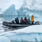 Zodiac cruising past icebergs, Antarctica.