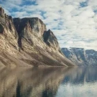 Baffin Island cliffs reflecting in calm waters, Arctic Canada.