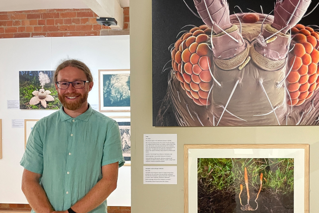 Alex Hyde with images featured in the exhibition.